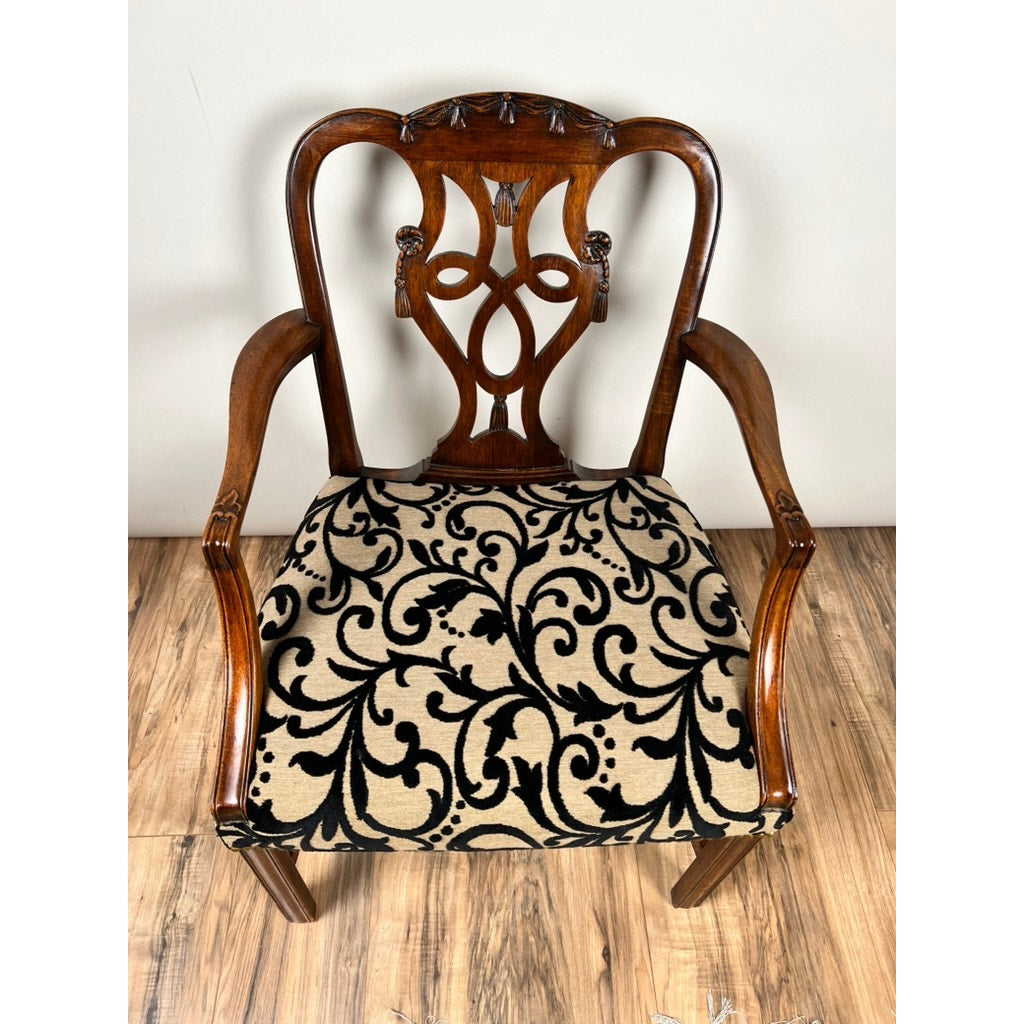 An Antique George III Chippendale Open Arm Chair (early 19th century) with a carved backrest and upholstered seat in cream with ornate black swirls sits on a wooden floor. Brand unknown.