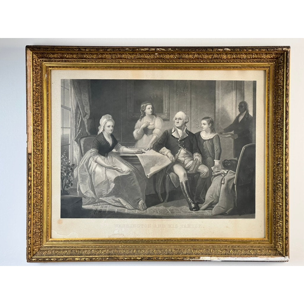 An antique 1858 engraving titled “Washington and His Family,” published by Bradley & Co., Philadelphia, is displayed here in a period gilt frame. The black-and-white print depicts George Washington seated at a table with his family, examining documents, and stands out elegantly against a plain white wall.