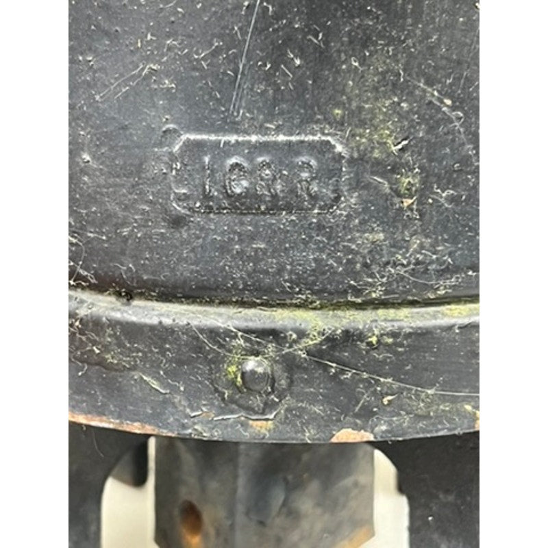 A close-up of a weathered black metal surface from an Antique Illinois Central Railroad Signal Lantern by Dressel, with "163R" embossed on it. The Dressel lantern shows rust, dirt, and green discoloration.