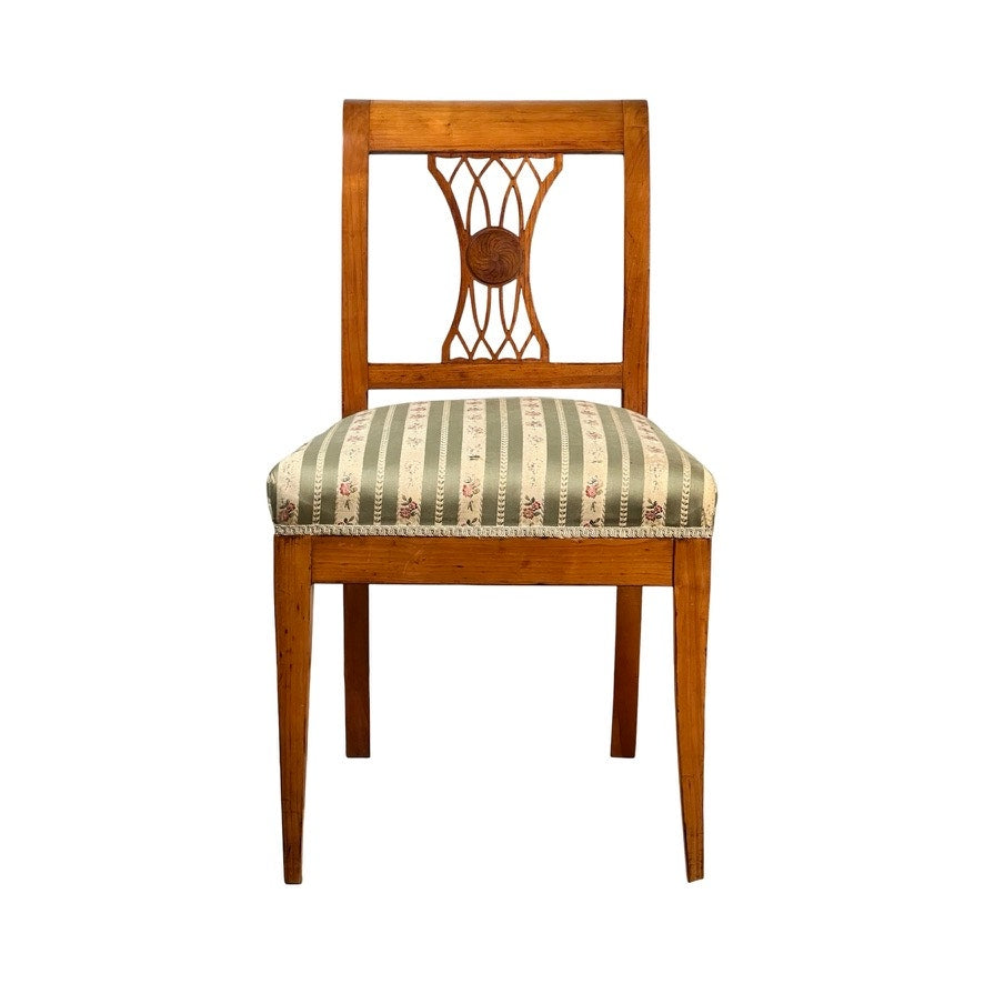 Antique German Biedermeier style cherry side chair, early 20th century, featuring a decorative openwork backrest and a green and beige striped cushioned seat with floral accents. Straight legs evoke classic antique charm. Brand: Unknown.