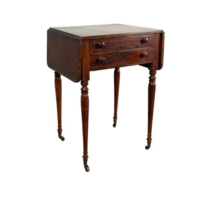 An English Regency Rosewood Two-Drawer Drop-Leaf Work Table with Brass and Satinwood Inlay, circa 1820–1840, featuring two drawers, drop leaves, and tapered legs set on casters.