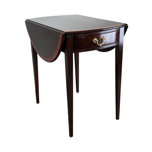 The Stickley Vintage Federal Style Edge Banded Mahogany End Table features slender legs, a single drawer with brass handle, and one leaf extended. Its classic design is perfect for elegant, traditional interiors.
