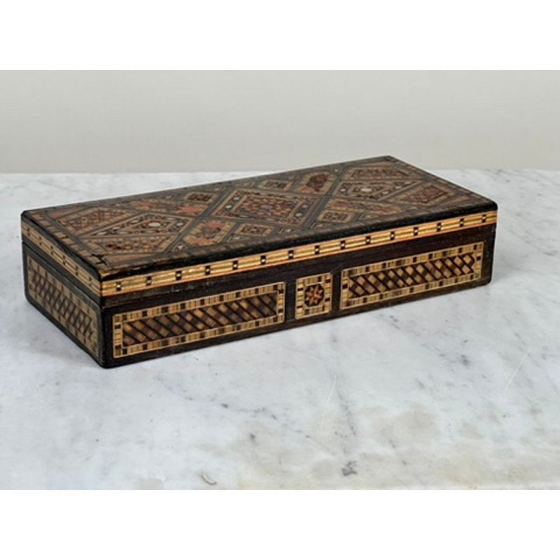 An Antique Persian (likely Syrian) Khatam Inlaid Wood Jewelry Box from the early 20th century, featuring geometric patterns in brown and beige tones, is displayed on a white marble surface. Brand unknown.