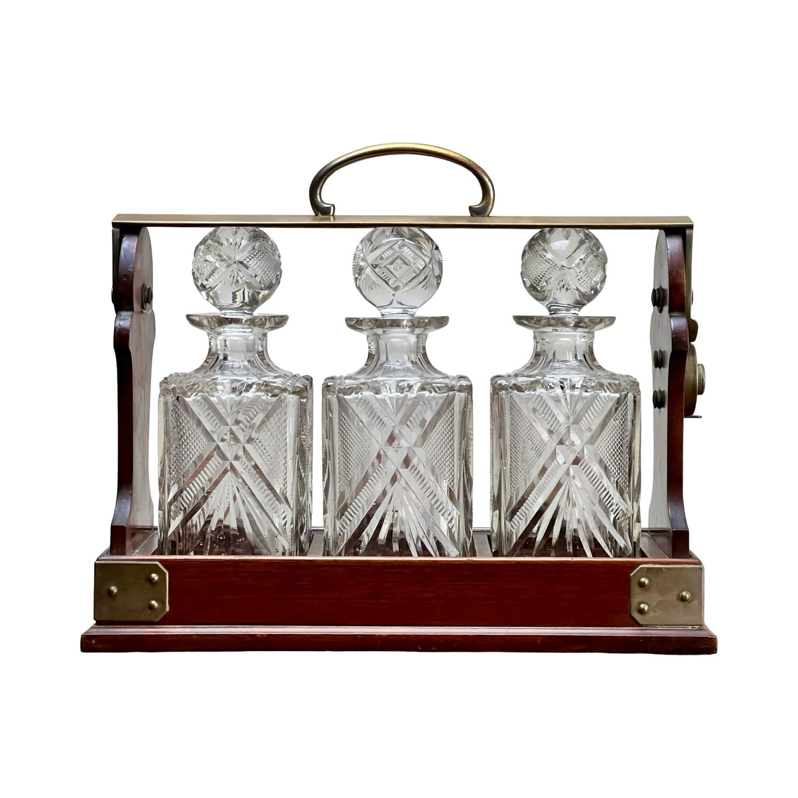 This Antique English Edwardian Betjemann’s Cut Crystal Three Bottle Tantalus (c. early 20th century) features three ornate crystal decanters with stoppers in a handled Betjemann’s case, each boasting intricate cut patterns.