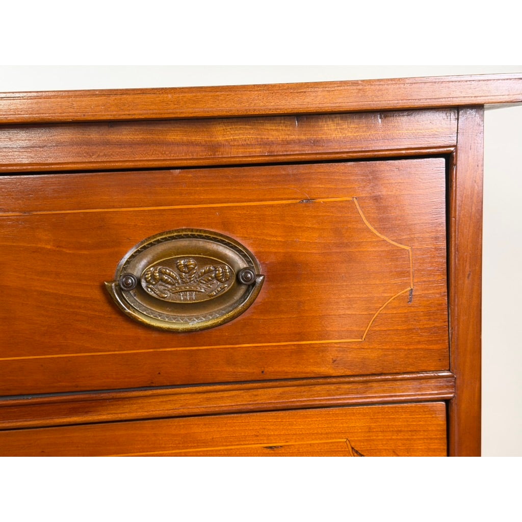 Close-up of a Pennsylvania Federal Cherry Four-Drawer Chest with Satinwood String Inlay, showing an oval brass handle and light wood inlay detailing.