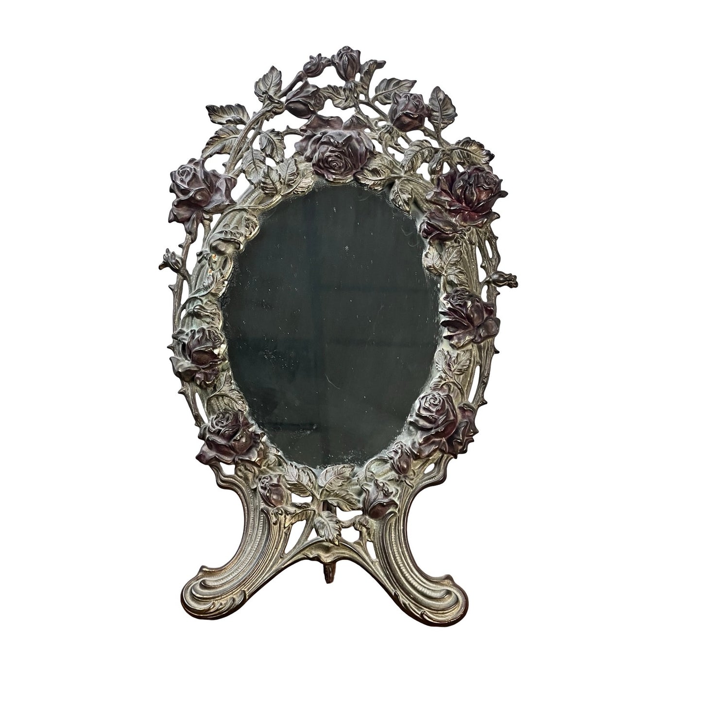 The Antique Art Nouveau Silvered Cast Brass Rose Vanity Dressing Mirror, dated 1909, features an ornate oval frame with rose and leaf designs in cast brass and stands elegantly on two curved legs. Brand unknown.