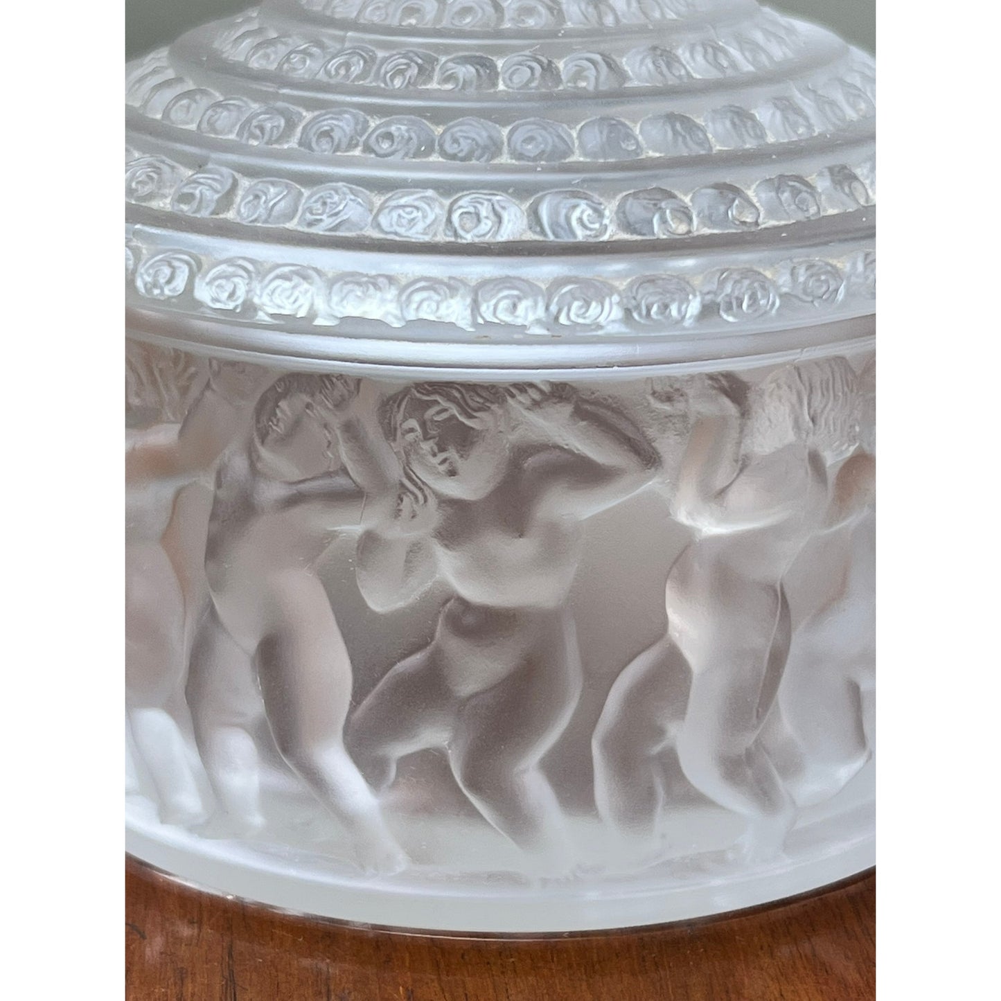 The Vintage Lalique Crystal Enfants Box by Lalique features frosted glass in the French art glass style, with classical reliefs of dancing nude figures encircling a round container and a decorative, textured lid.