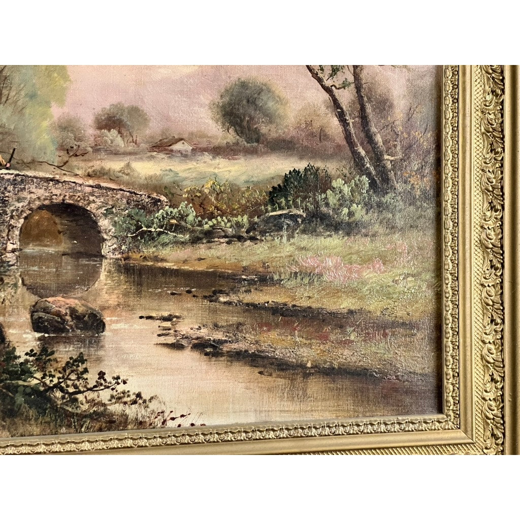 The "Spectacle Bridge" is an antique early 20th-century oil on canvas painting signed Arthur Davis lower left, showing a stone bridge over a calm river with trees, grass, and houses beneath a cloudy sky, set in an ornate gold frame.