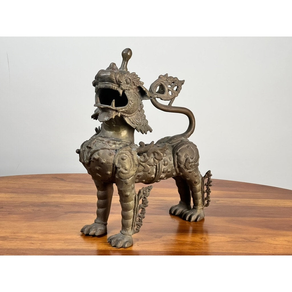 A Vintage 17” Cast Brass Pixiu Tibetan Lion (c. 1960) with ornate details and a curled tail stands elegantly—a striking piece for collectors of Asian decorative arts or Tibetan Chinese decor. Brand: Unknown.