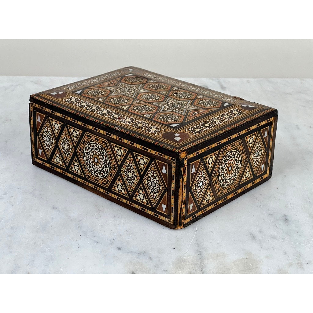 Antique Persian (probably Syrian) Khatam inlaid wood secret drawer jewelry box, late 19th century, featuring intricate geometric patterns in brown, black, and white, displayed on a white marble surface. Brand: Unknown.