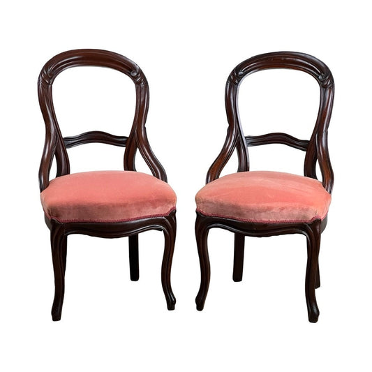 A beautifully crafted antique pair of Victorian walnut balloon back side chairs with curved legs, featuring vintage rose velvet upholstery for timeless appeal. Brand is unknown.