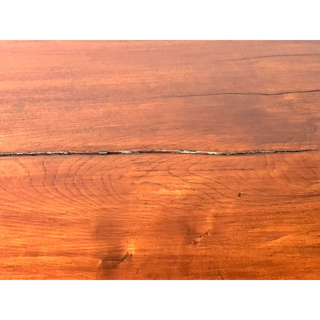 A close-up of the wood grain and natural texture of an Antique Sheraton Mahogany Bowfront Chest (early 19th century), showing a visible horizontal crack across the center. Brand: Unknown.