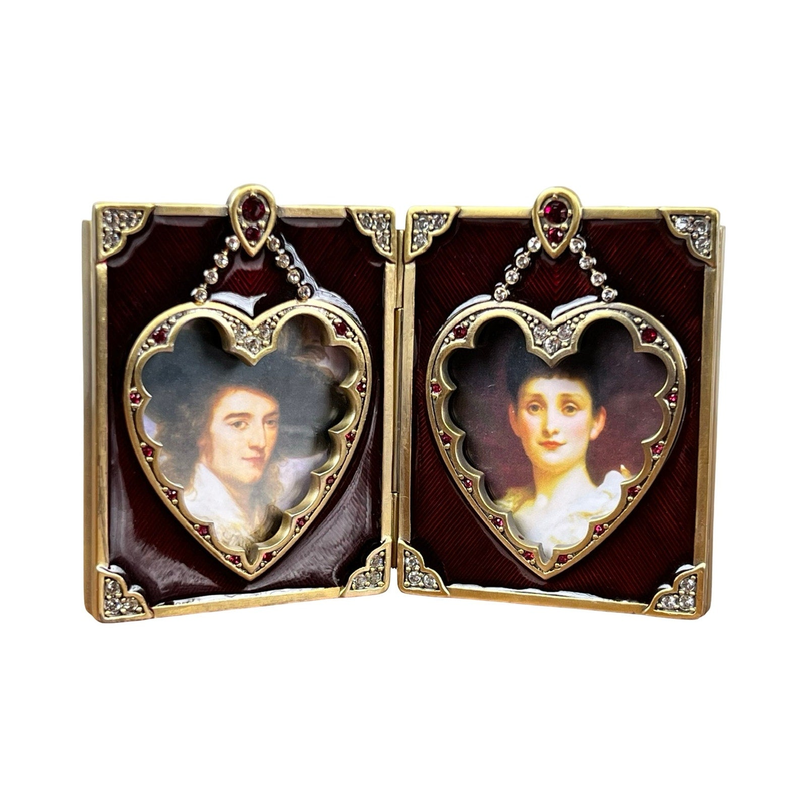 The New in Box Jay Strongwater Bejeweled Enamel Double Heart Picture Frame features gold trim, red accents, and displays two portraits side by side in an open locket design.