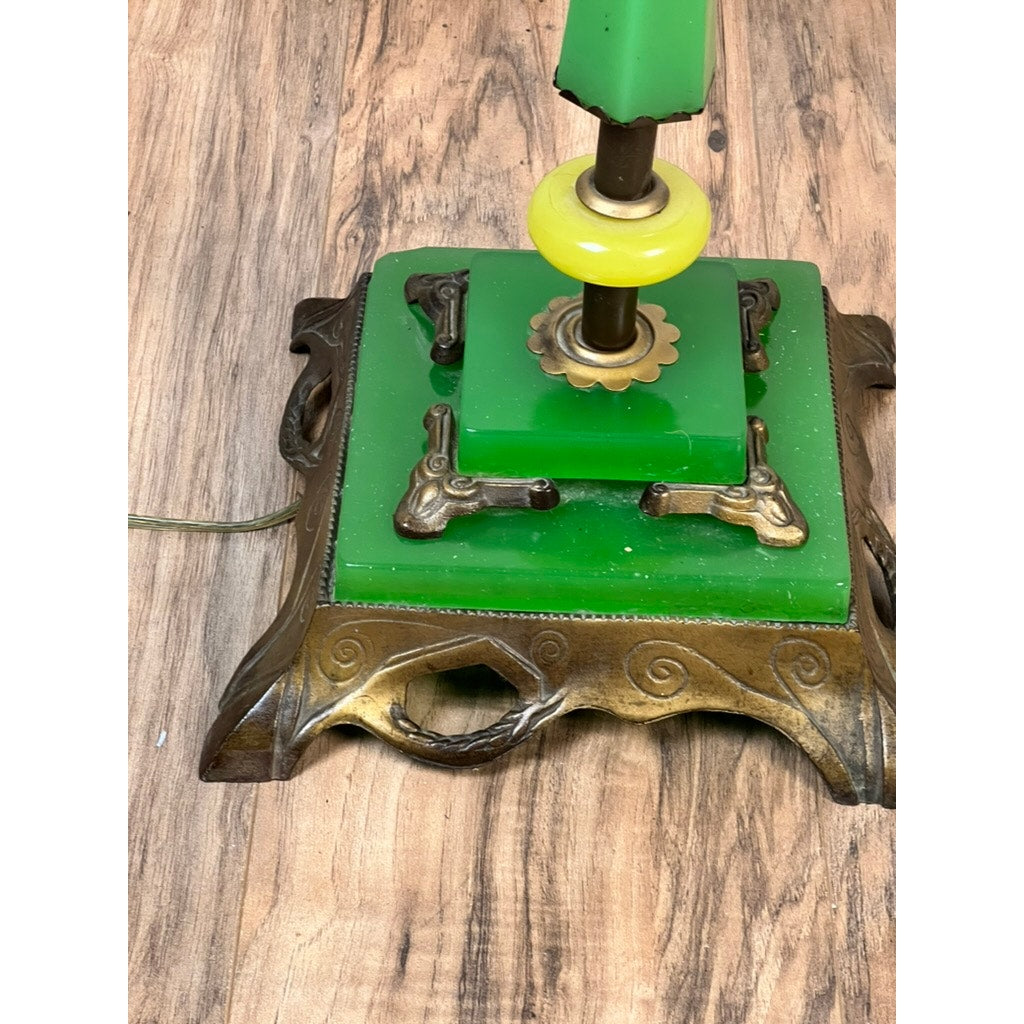 Close-up of an Antique Art Deco Uranium and Slag Glass Lamp c. 1920 with green glass, bronze scrollwork base on wood; cord visible on the left. Brand: Unknown.