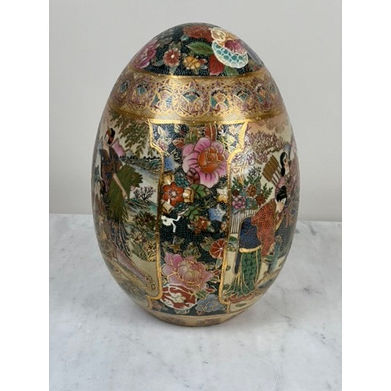 A large antique Satsuma porcelain egg, Chinese export, features intricate colorful floral patterns and detailed scenes of people in traditional Asian attire—a prized collectible with unknown brand.