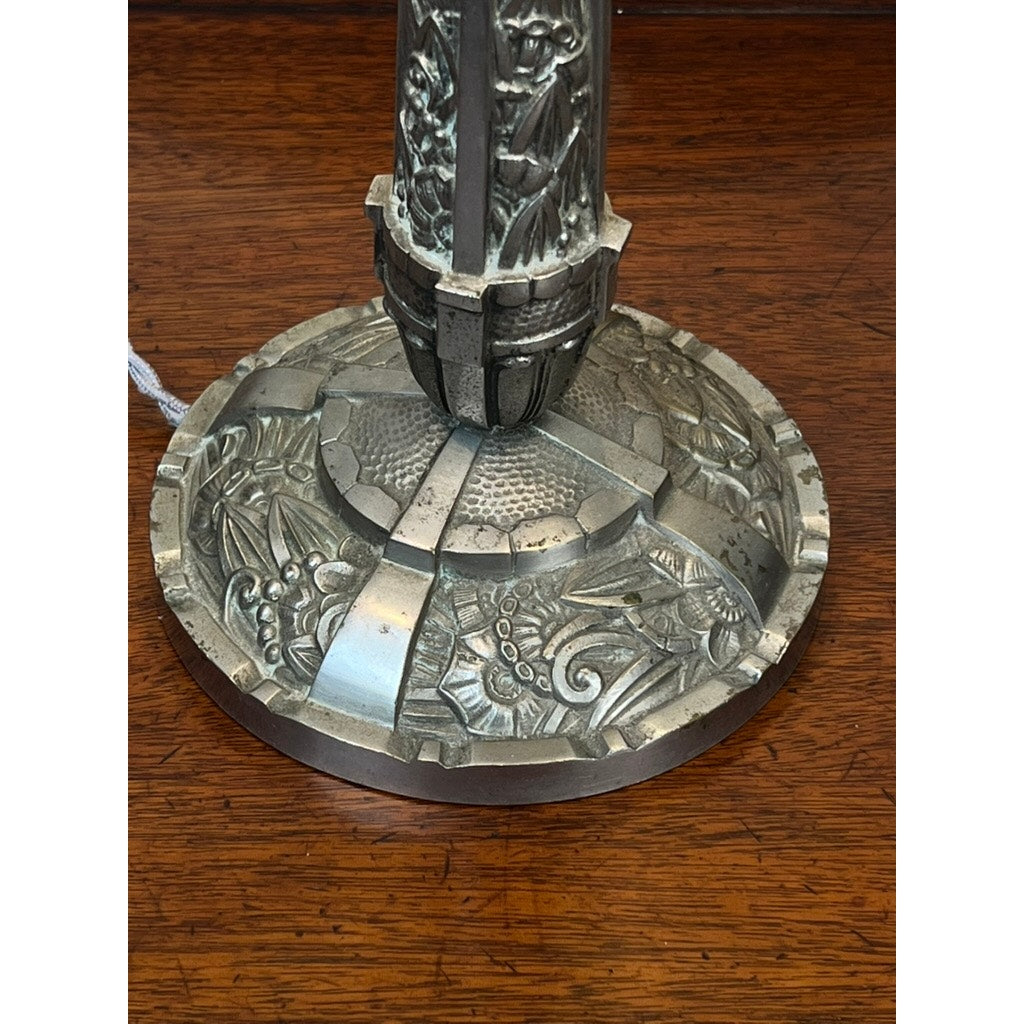 A close-up of a Vintage French Art Deco Frosted Glass Table Lamp by Muller Frères Lunéville c. 1920, featuring an ornate embossed base with fish, leaves, and geometric patterns beneath a frosted glass shade on wood.