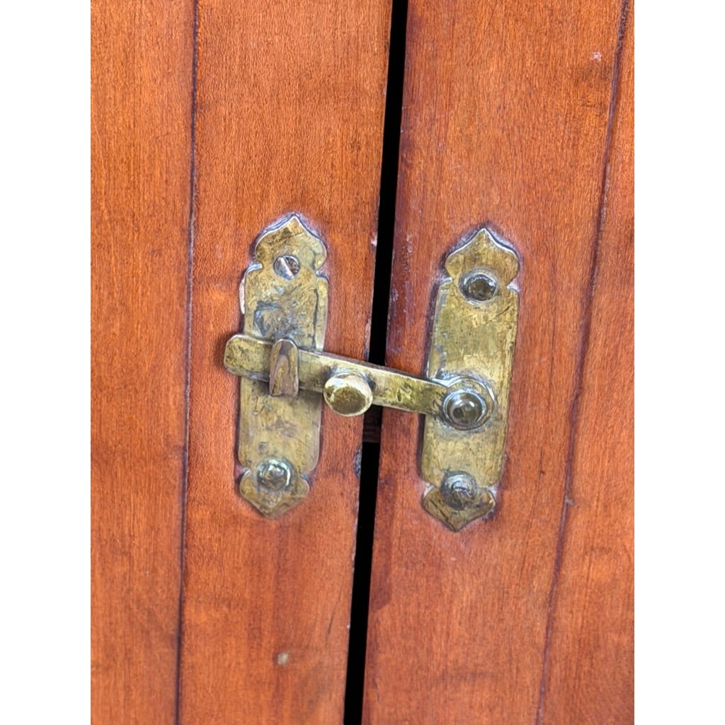 A brass latch locking the doors of a Pennsylvania or Mid-Atlantic Cherry Open Pewter Cupboard, circa 1800–1830.
