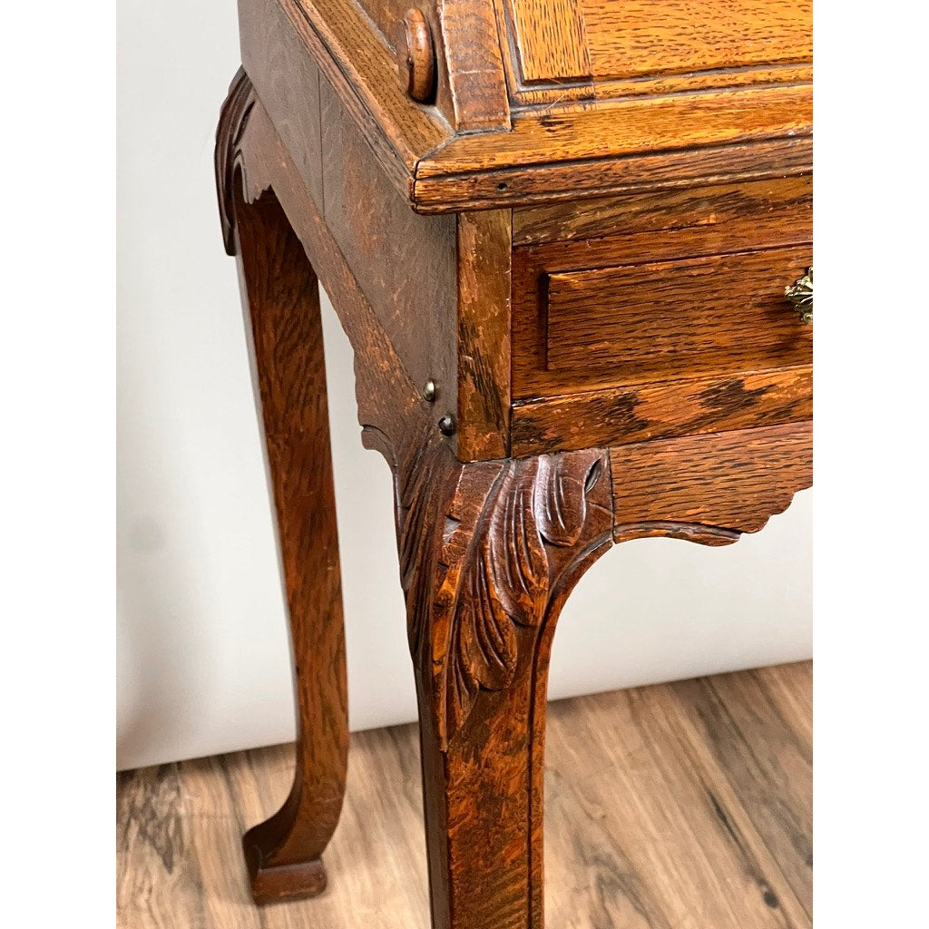 Close-up of an Antique Victorian Oak Ladies Writing Desk c. 1900, featuring ornate carved legs and corners, a warm rich finish, and standing elegantly on a wooden floor. Brand: Unknown.