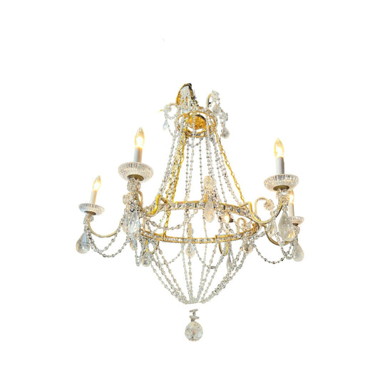 The Vintage Empire Style Brass and Rock Crystal Six Light Chandelier features six candle-style bulbs, clear bead drapes, and teardrop ornaments, exuding timeless elegance against a white background. Brand: Unknown.