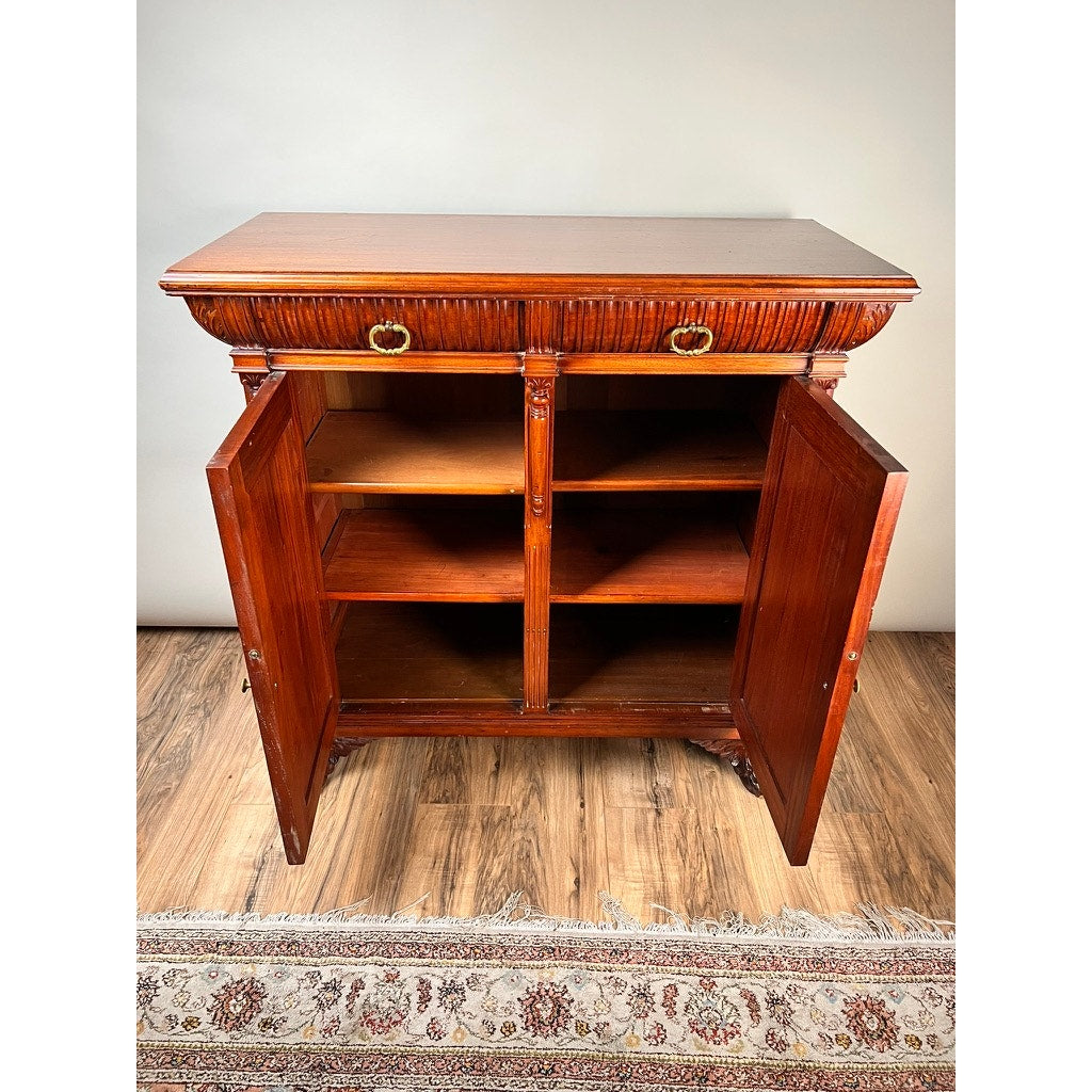 The Antique English Jacobean Revival Mahogany Buffet c. 1915–1925 features two open front doors revealing four interior shelves, two top drawers with brass handles, and stands on a decorative rug over a hardwood floor. Brand: None/Unknown.