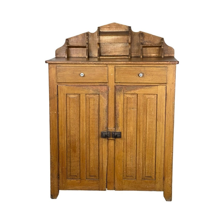 The Antique Victorian Country Grain Painted Jelly Cupboard c. 1870 features two paneled doors, two small drawers, a tiered open-shelf top, natural wood finish, and dark metal hardware for a classic vintage look. Brand is None and/or Unknown.