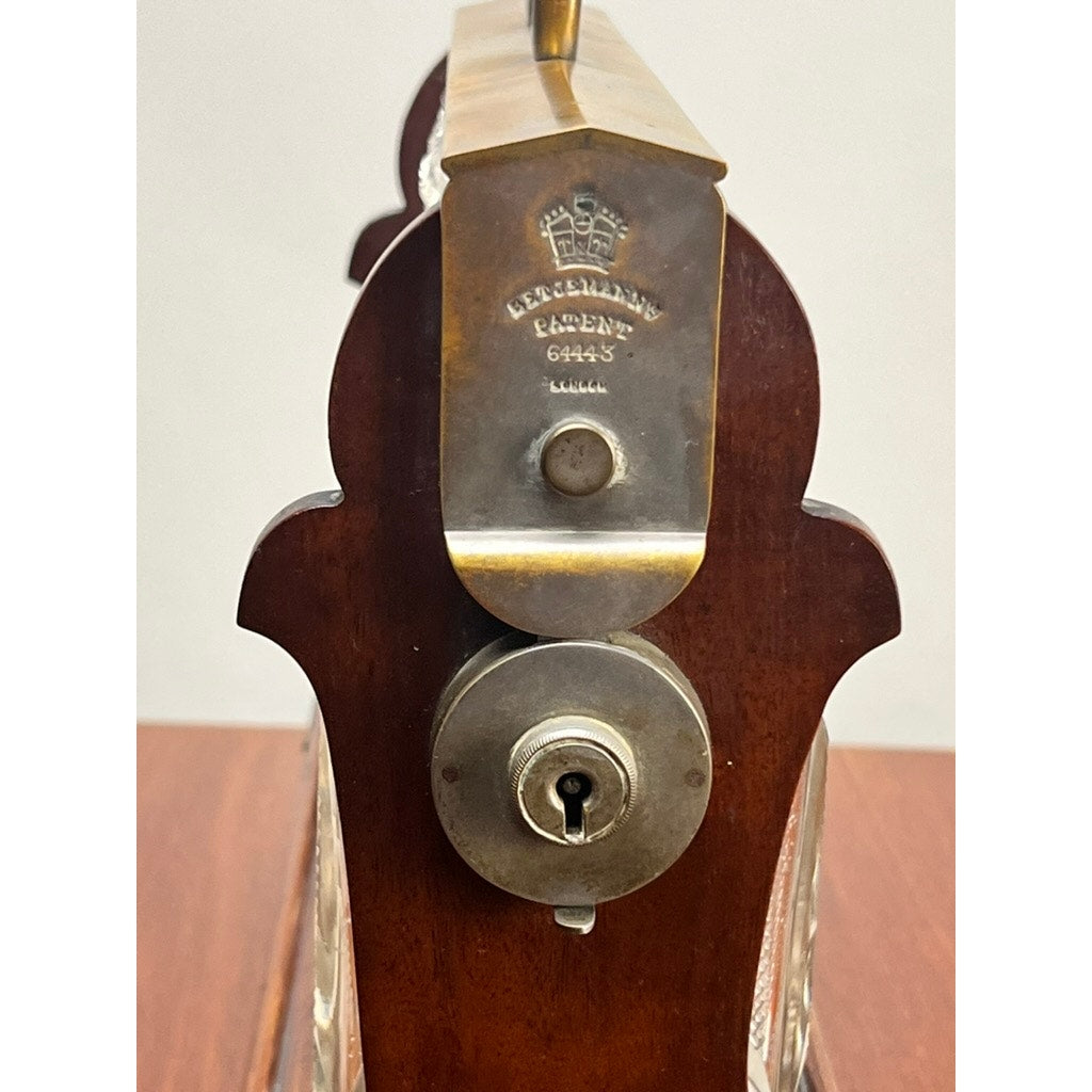 Close-up of the locking mechanism on the Antique English Edwardian Betjemann’s Cut Crystal Three Bottle Tantalus (c. early 20th century) by Betjemann's, with keyhole and engraved “BETJEMANNS PATENT 69453”—ideal for stylishly securing your decanters.