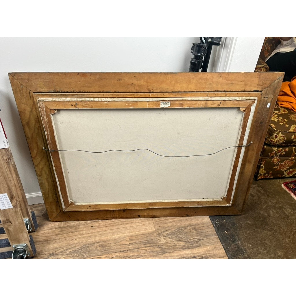 The painting “Mallards Over Marsh,” an oil on canvas by Joseph Glotzer, is shown from the back with its wooden frame and hanging wire. It rests on a hardwood floor near a brown patterned chair and some equipment.