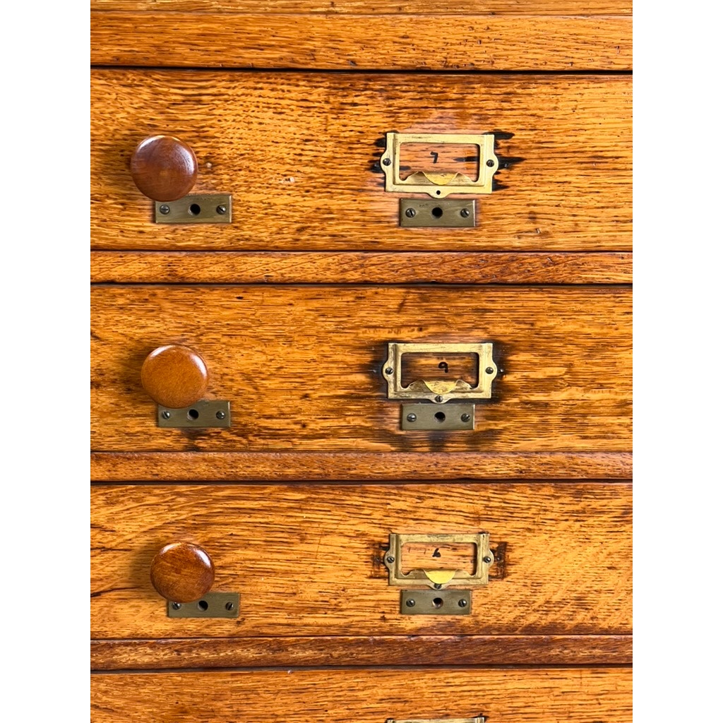 Close-up of three drawers from an Antique Early 20th Century Oak Multidrawer File with Roll Top Pigeon Hole Top, featuring round knobs, brass label holders with keyholes, and showcasing the oak’s rich grain and warm color.