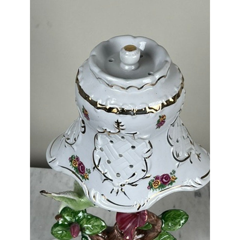 A close-up of the Vintage Lena Liu Porcelain Hummingbird Accent Lamp, featuring gold accents, floral designs, a perforated scalloped shade, and intricate painted flowers near the base in Lena Liu's delicate style.