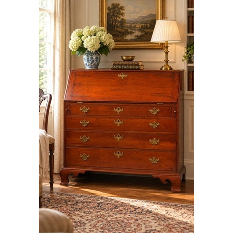 A Chippendale Cherry Slant-Front Desk with Ogee Bracket Feet, possibly Connecticut River Valley, circa 1770–1790, is an 18th-century cherry wood slant-front desk featuring four drawers, brass pulls, and ogee bracket feet.