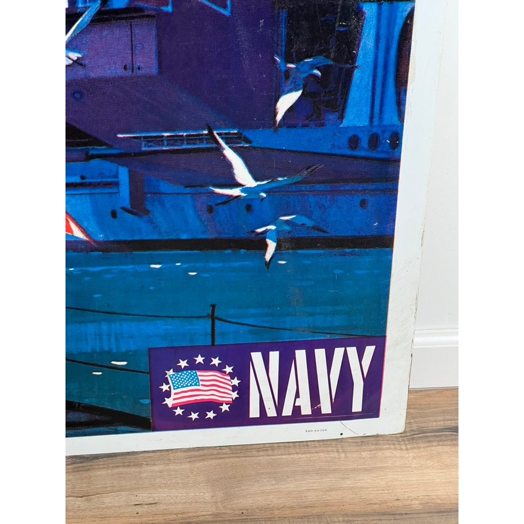 Partial view of an original Vietnam Era double sided U.S. Navy recruiting tin sign by artist Lou Nolan, featuring seagulls over water, USS Saratoga, bold white NAVY lettering, and a stylized American flag on a purple background.