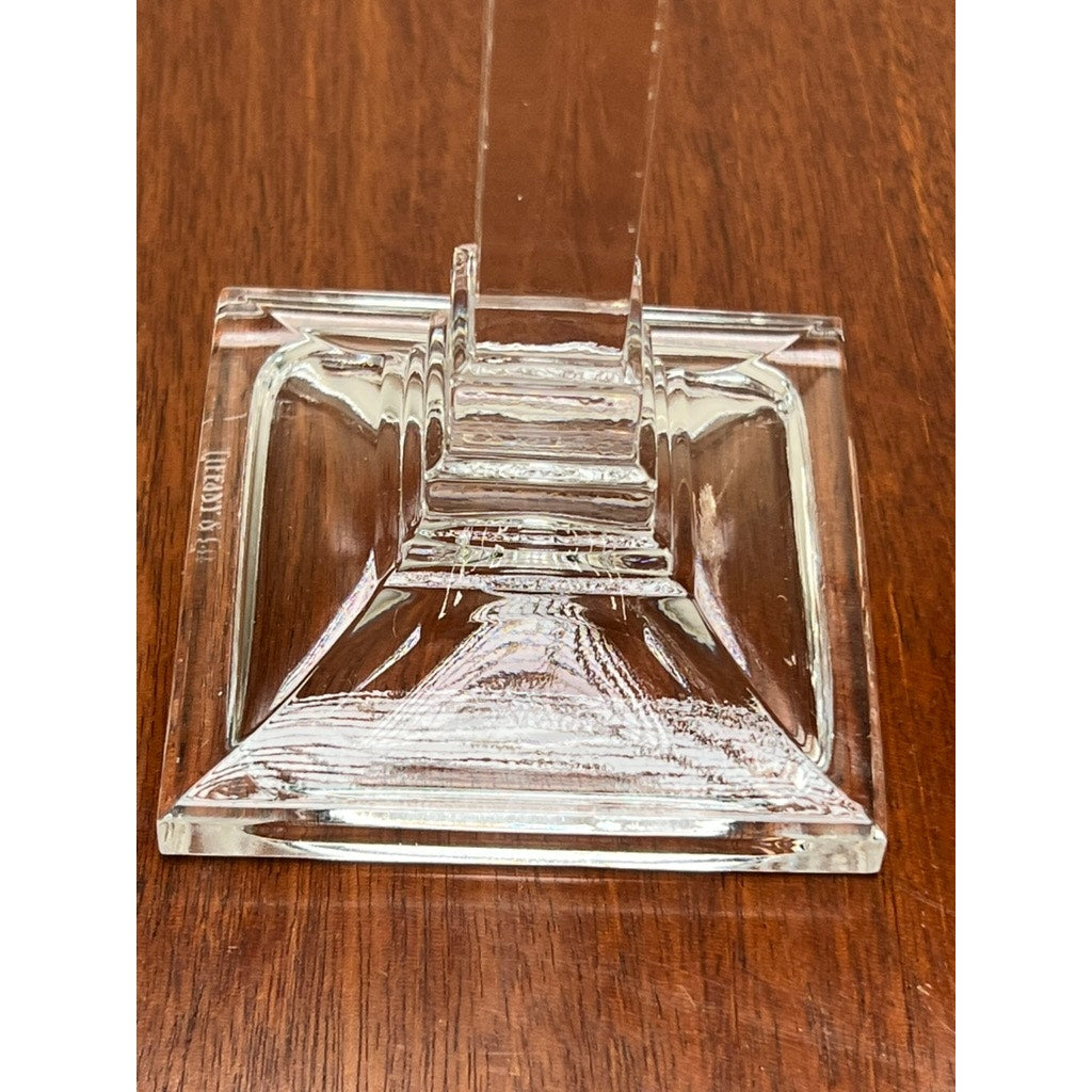 The Vintage Pair Tiffany & Co Clear Crystal Candlesticks by Tiffany & Co. feature clear stepped glass square bases and vertical columns, recalling classic elegance as they rest on a brown wooden surface.