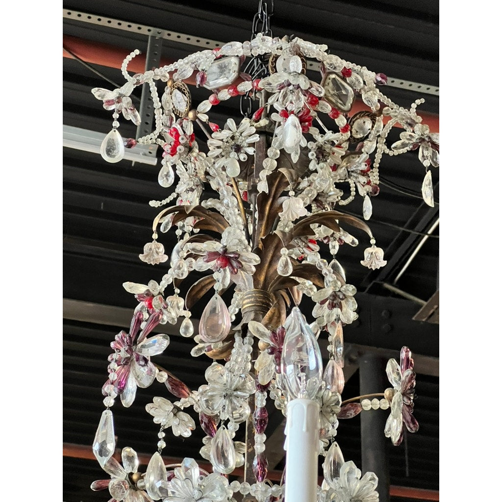 A close-up of an Antique Late 19th Century French Rococo Tole Amethyst and Crystal Ten Light Chandelier, hanging from a chain against an industrial black ceiling with exposed pipes and beams.