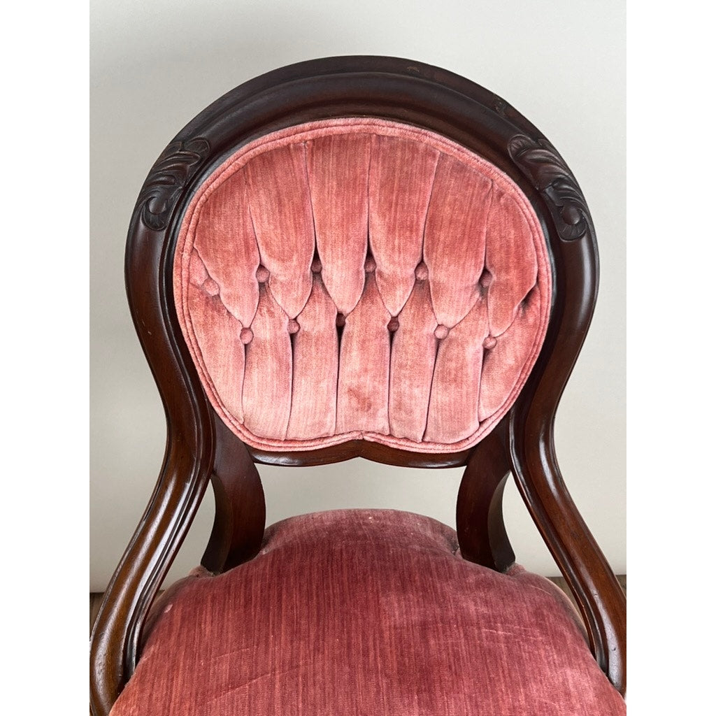 A close-up of the Antique Victorian Walnut Tufted Balloon Back Side Chair, late 19th century, featuring a dark walnut frame and pink tufted velvet upholstery on its rounded backrest and seat.