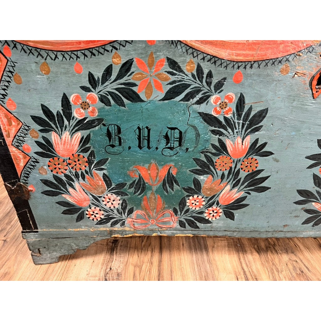 This Antique Swedish Oak Kista Dowry Chest c. 1841 features a painted wooden surface with orange, black, and white floral designs, and decorative script letters B.U.D. inspired by Swedish folk art. Brand: None/Unknown.