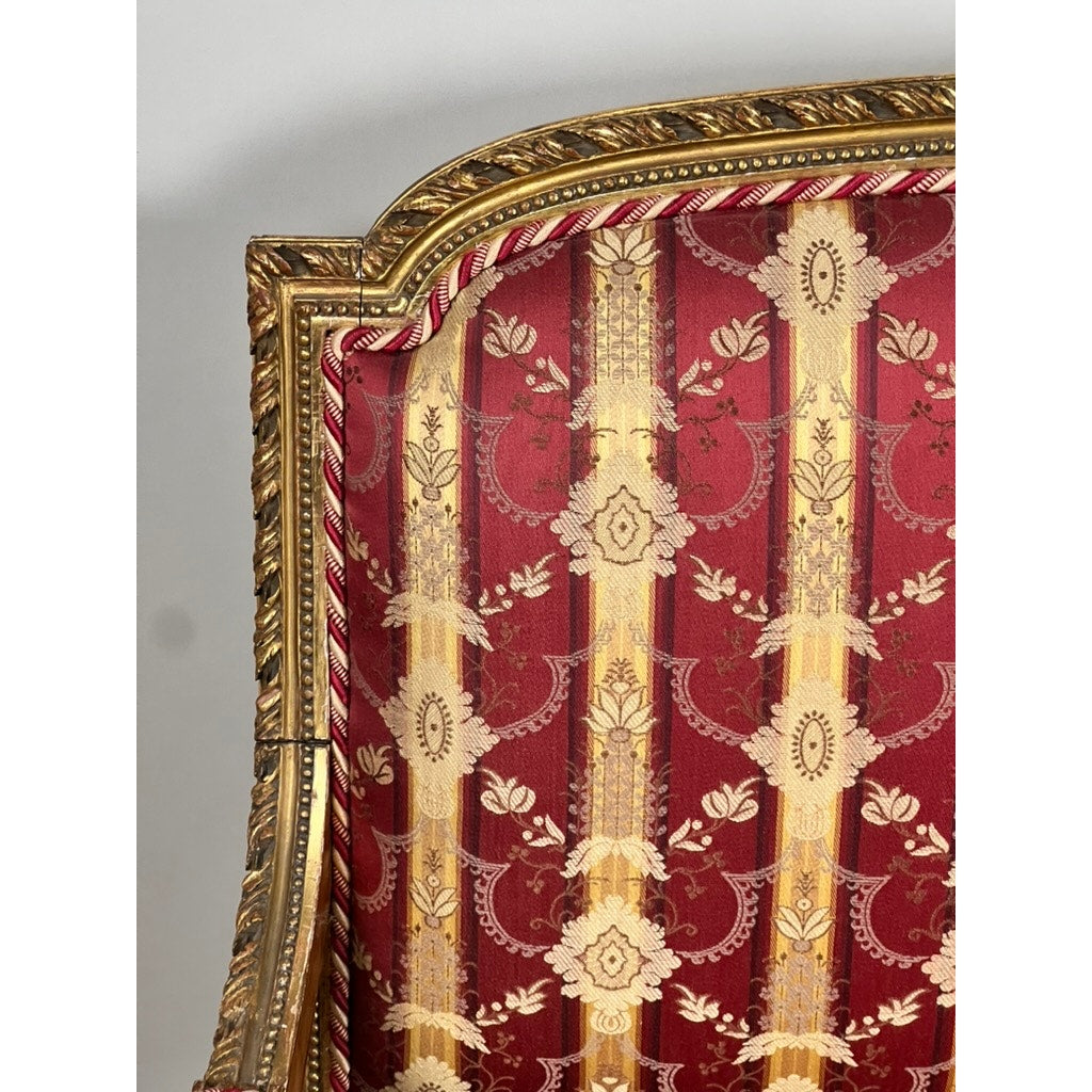 Close-up of an Antique Louis XVI Style Giltwood Settee in Silk Damask (late 19th century), showing its gold-painted frame and red floral-patterned upholstery against a plain white background. Brand unknown.