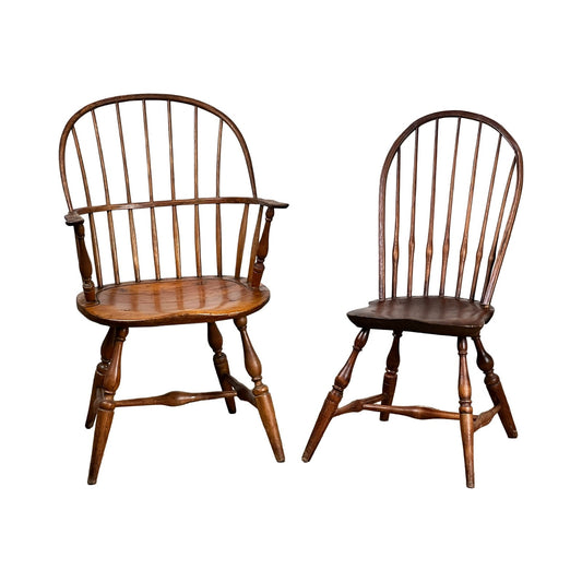 This Antique Near Pair 18th Century Windsor Chairs set includes one with armrests and a curved back, the other armless. Both feature spindle backs, splayed legs, and a rustic vintage style that reflects early American craftsmanship. Brand: Unknown.